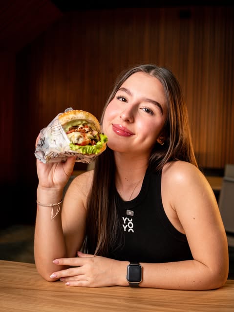 Cliente disfrutando una hamburguesa Mack Family